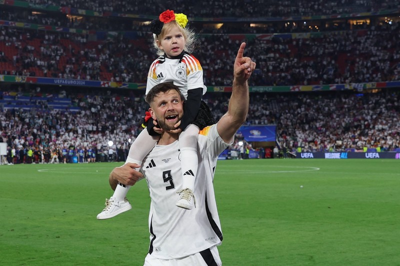 Niclas Füllkrug zeigt seiner Tochter das Spielfeld nach dem Sieg gegen Schottland.