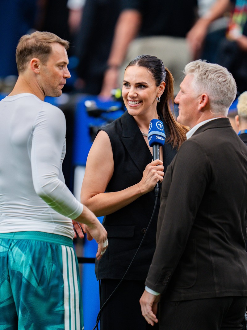 Esther Sedlaczek und Bastian Schweinsteiger necken sich wieder vor dem Spiel am Spielfeldrand.